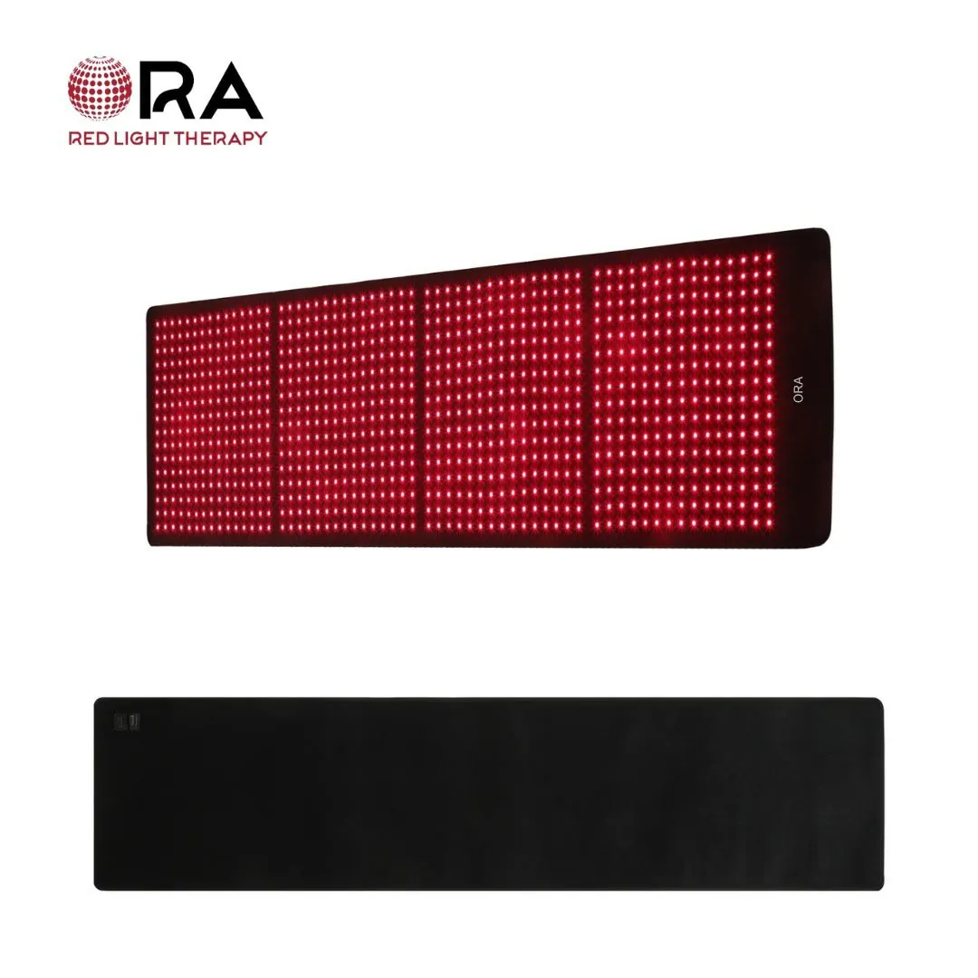 ORA full-body red light therapy mat shown lit with red LEDs and from the plain back side